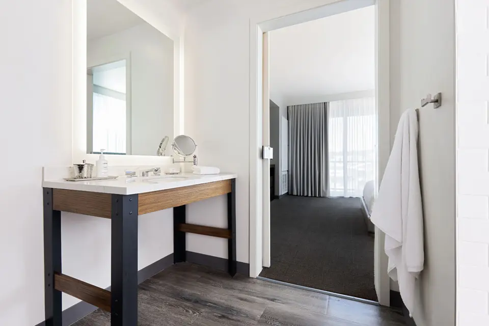 Modern bathroom with weathered iron vanity, mirror and luxury bath amenities