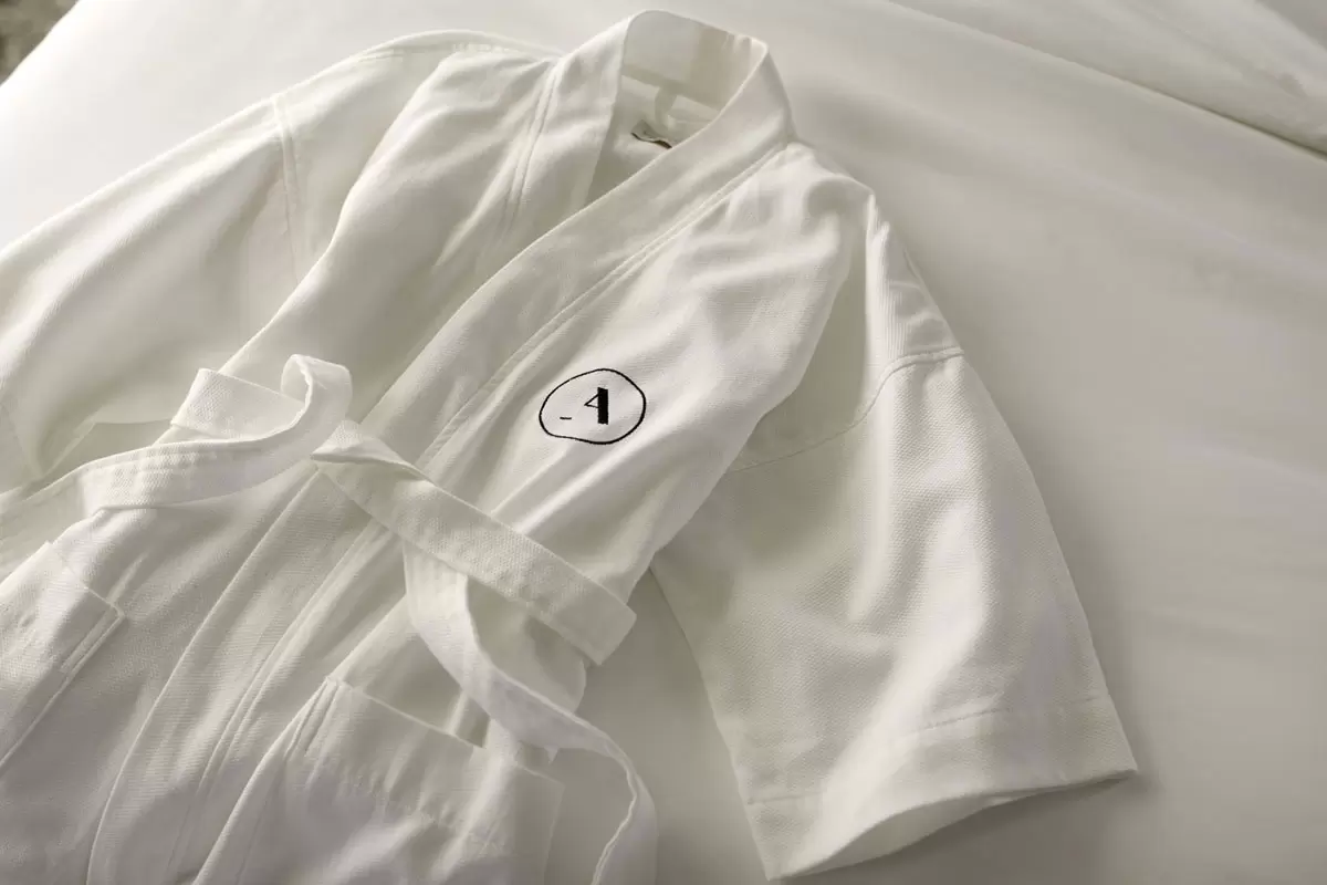 White Frette Archer robe on white bedding