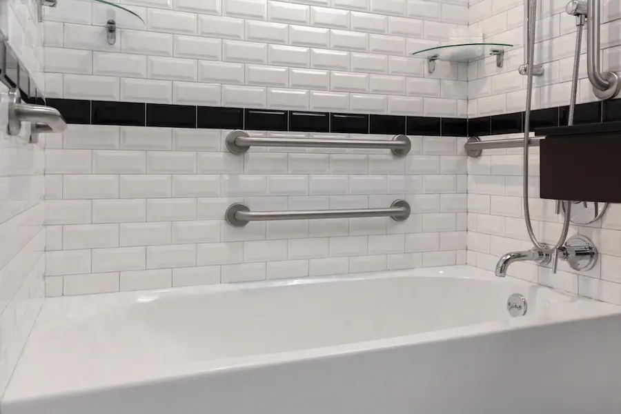 Classic King - mobility-accessible tub with grab bars and subway-tile walls