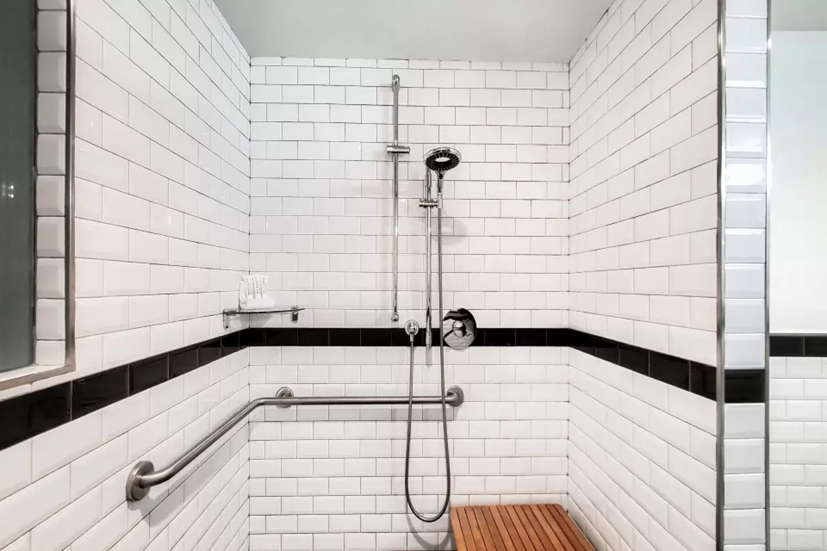Double Double - mobility-accessible roll-in shower with grab bars, hand-held shower wand and subway-tile walls