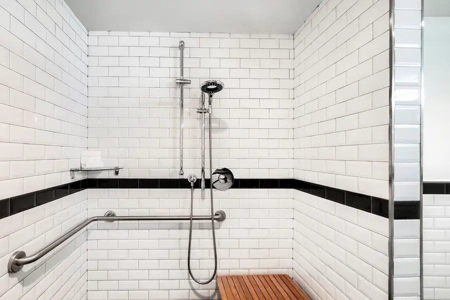 Double Double - mobility-accessible roll-in shower with grab bars, hand-held shower wand and subway-tile walls