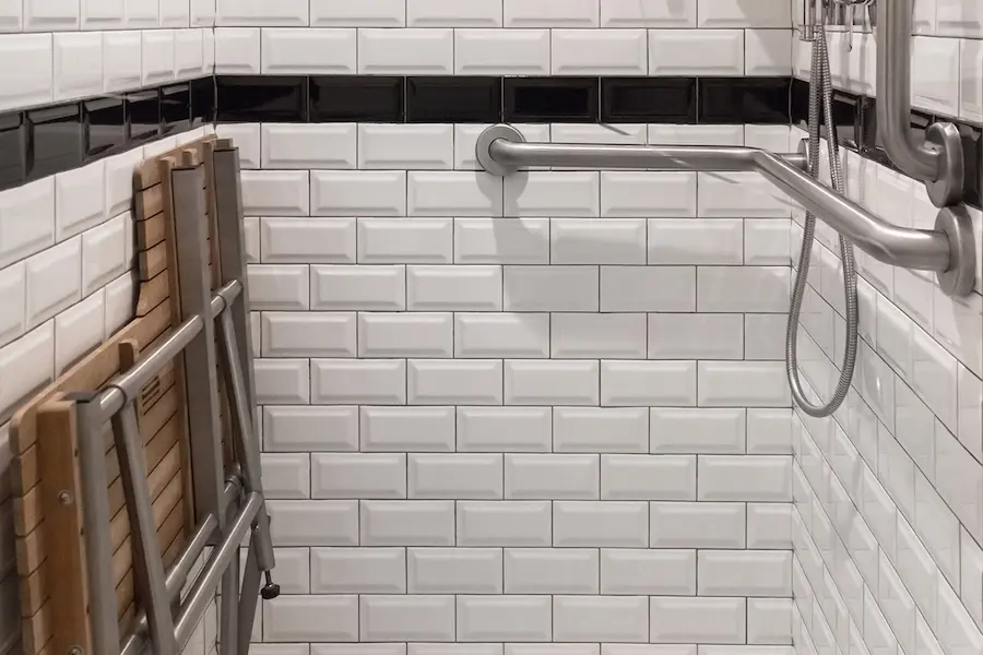 Archer King Empire View - mobility-accessible transfer shower with shower seat and subway-tiled walls