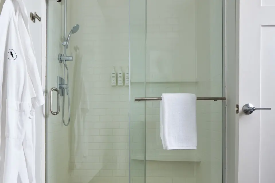 Classic King - modern bathroom with white subway-tile walk-in shower and hanging Frette bathrobe
