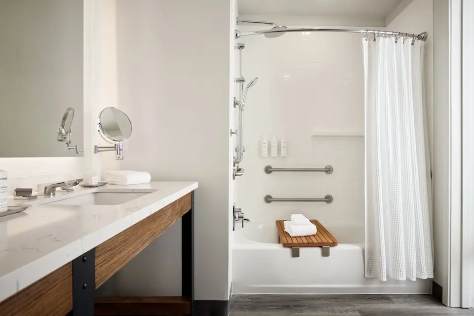 Double King - mobility-accessible tub with grab bars and hand-held shower wand