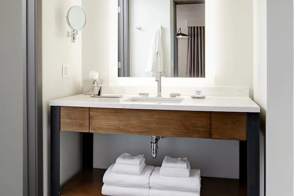 Archer’s Den - modern bathroom with weathered iron vanity, mirror and luxury bath amenities