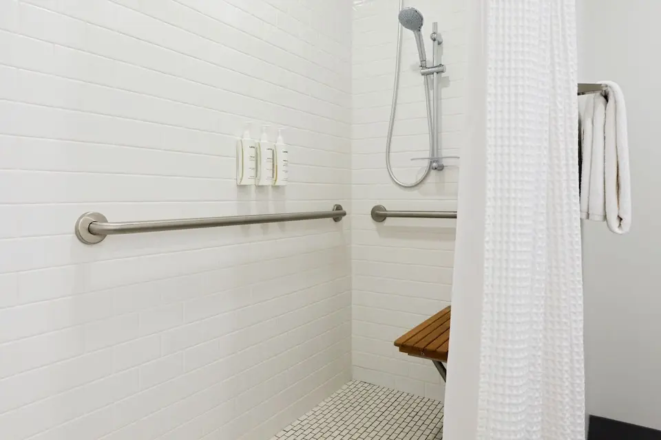 Archer’s Den - mobility-accessible roll-in shower with shower seat, hand-held shower wand and grab bars