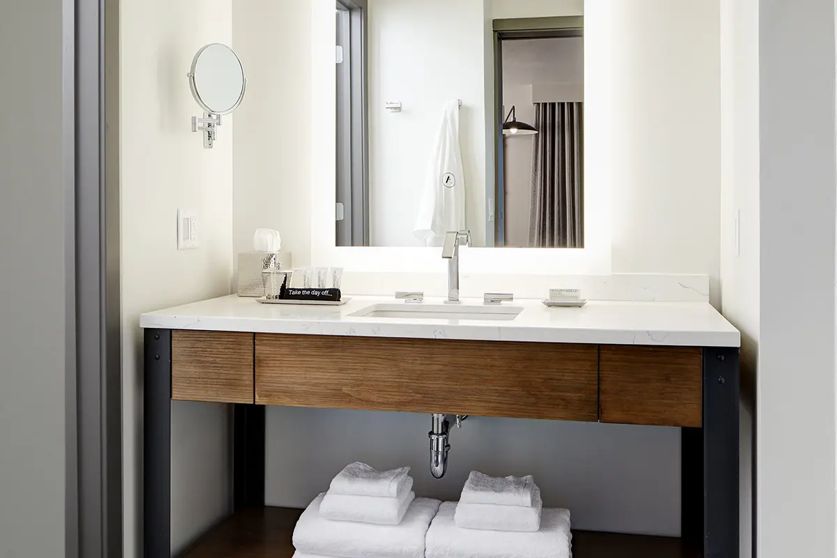 Modern bathroom with weathered iron vanity, mirror and luxury bath amenities