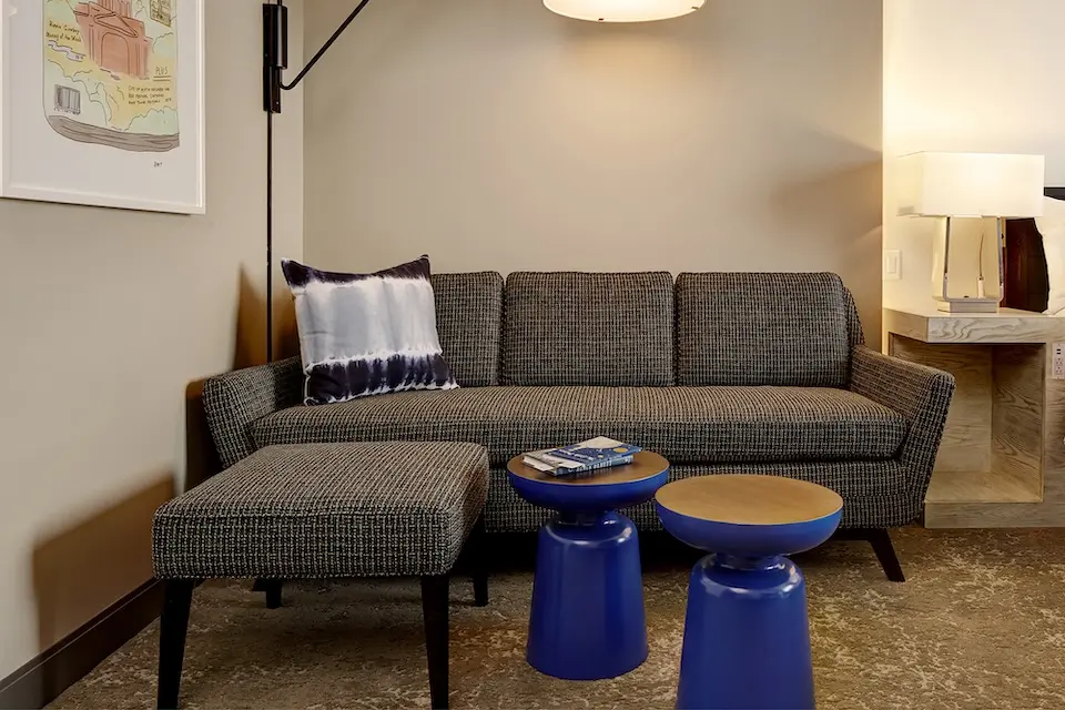 King Balcony Suite - living area with sofa and ottoman