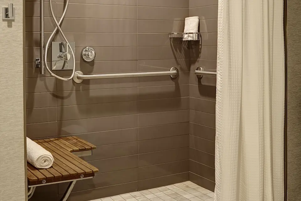Archer King Suite - mobility-accessible roll-in shower with shower seat, hand-held shower wand and grab bars