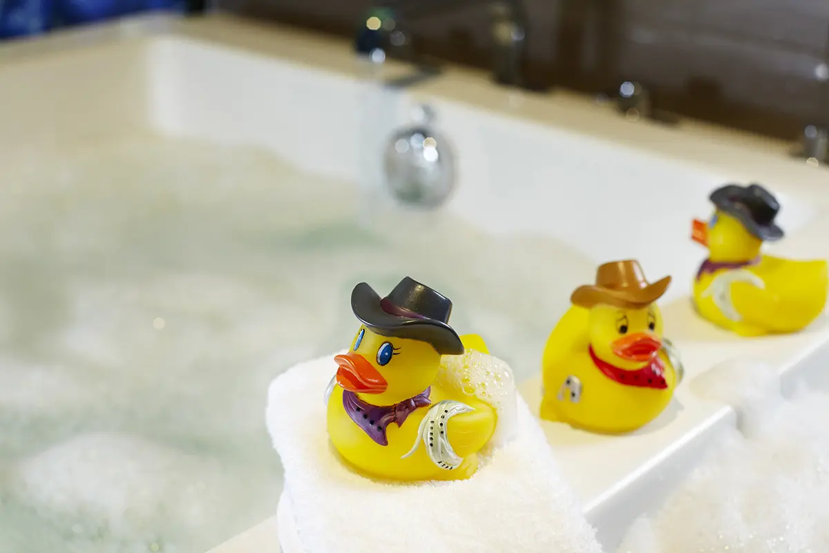 Archer's Den - Texas rubber duckies sitting on edge of soaking tub